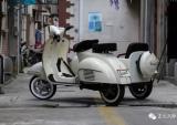 一辆存放在老巷口的电动Vespa